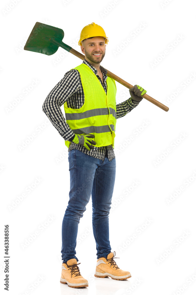 Smiling construction worker is standing with shovel on his shoulder. Studio shot on white background. Smiling construction worker is standing with shovel on his shoulder. Studio shot on white background.