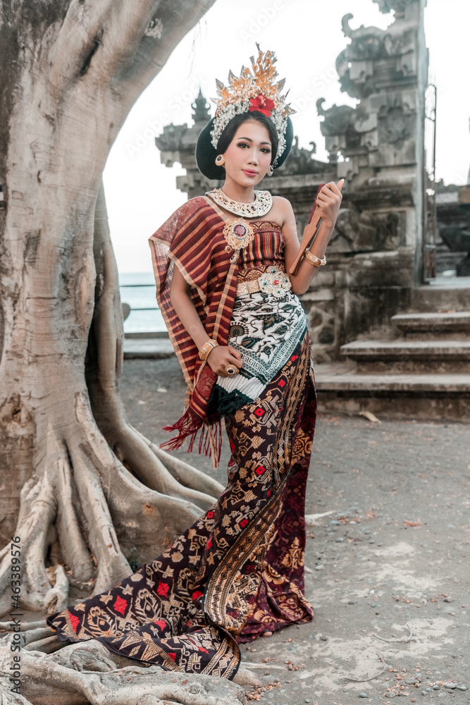 Balinese woman in traditional costume and hand fan, indonesian girl, hindu temple background, Bali. Balinese woman in traditional costume and hand fan, indonesian girl, hindu temple background, Bali.