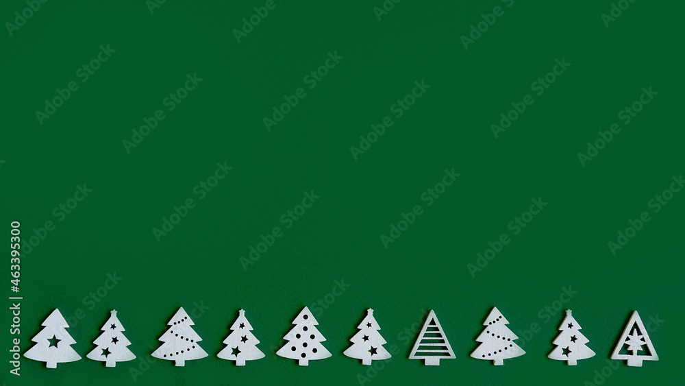small figures of Christmas trees on a green background ,a Christmas concept with a place for text small figures of Christmas trees on a green background ,a Christmas concept with a place for text