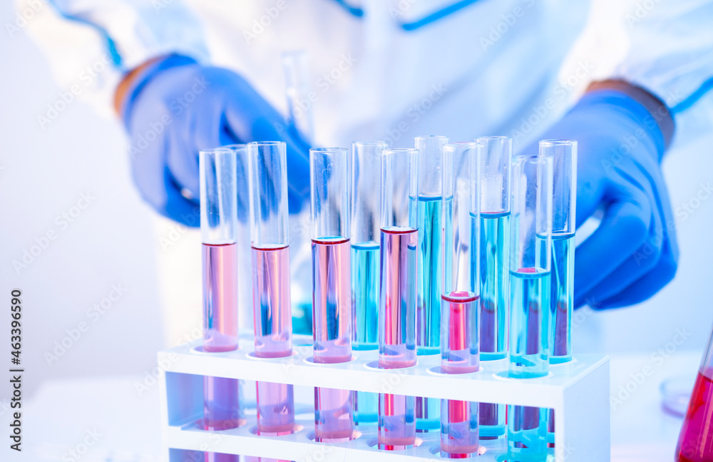 Coronavirus Delta variant vaccines producing in laboratory in glass tubes. Epidemiologist working on background Coronavirus Delta variant vaccines producing in laboratory in glass tubes. Epidemiologist working on background