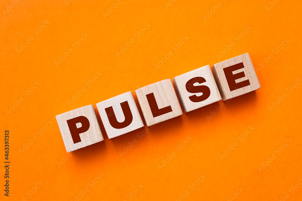 Obraz premium Wooden cubes with letters on a white table. The word is PULSE.