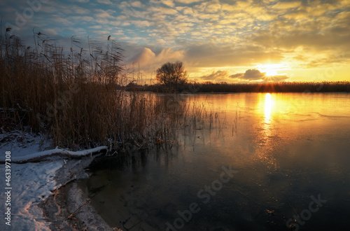 Sunrise and frozen sea. Beautiful winter landscape with lake in sunset time.