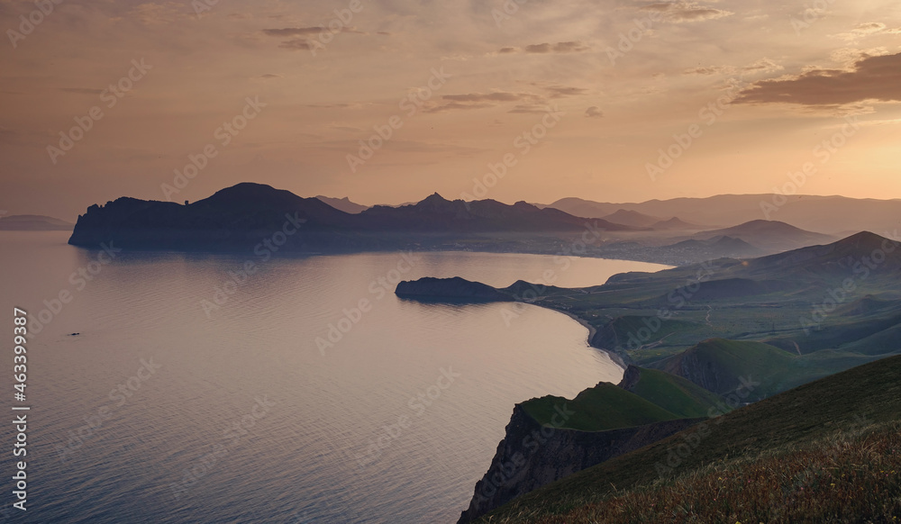 Beautiful sunset with rays over the contours of mountains with stones and sea. viewpoint between Ordzhonikidzhe and Koktebel