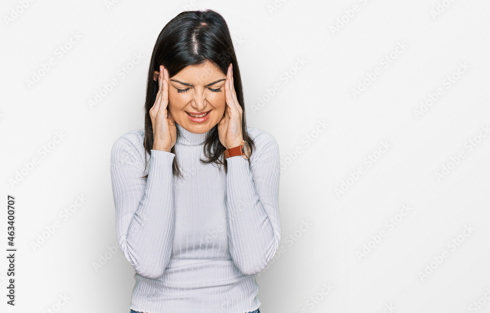 Beautiful brunette woman wearing casual clothes with hand on head, headache because stress. suffering migraine. Beautiful brunette woman wearing casual clothes with hand on head, headache because stress. suffering migraine.