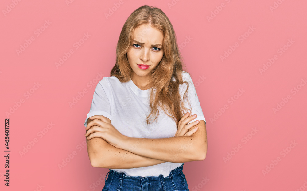 Young caucasian girl wearing casual white t shirt skeptic and nervous, disapproving expression on face with crossed arms. negative person. Young caucasian girl wearing casual white t shirt skeptic and nervous, disapproving expression on face with crossed arms. negative person.
