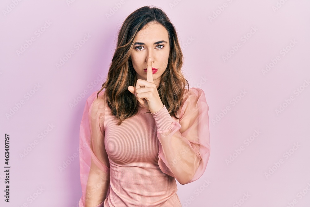 Obraz premium Young hispanic girl wearing casual clothes asking to be quiet with finger on lips. silence and secret concept.