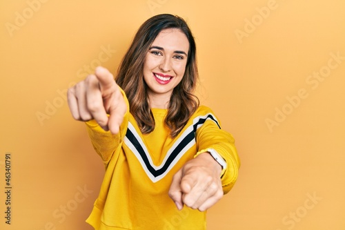 Young hispanic girl wearing casual clothes pointing to you and the camera with fingers, smiling positive and cheerful