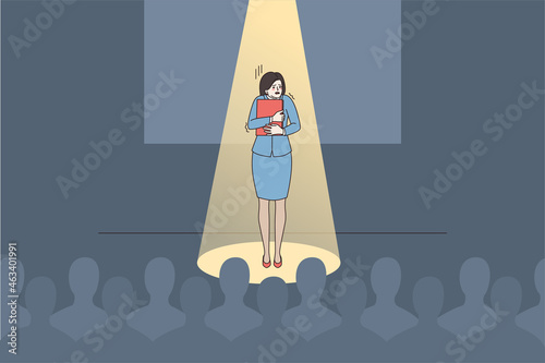Anxious young woman speaker or presenter feel scared nervous of public speaking. Worried female stand on stage unconfident shy talking making presentation in front of audience. Vector illustration. photo