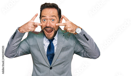 Middle age man wearing business clothes doing peace symbol with fingers over face, smiling cheerful showing victory