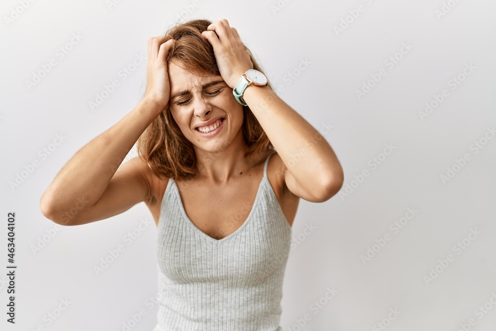 Beautiful caucasian woman standing over isolated background suffering from headache desperate and stressed because pain and migraine. hands on head. Beautiful caucasian woman standing over isolated background suffering from headache desperate and stressed because pain and migraine. hands on head.