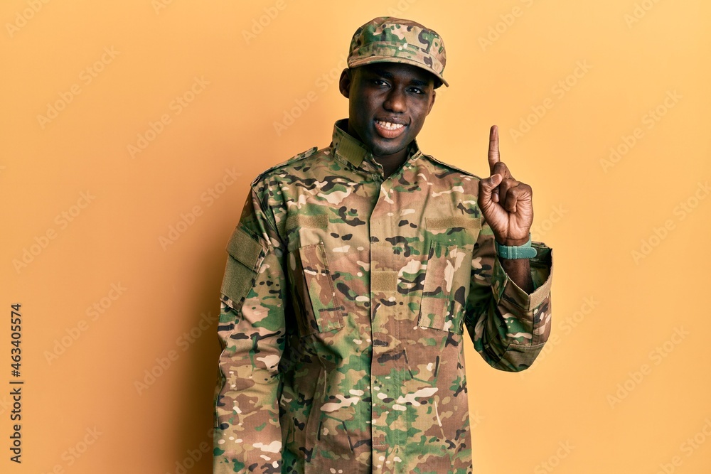Young african american man wearing army uniform pointing finger up with successful idea. exited and happy. number one. Young african american man wearing army uniform pointing finger up with successful idea. exited and happy. number one.