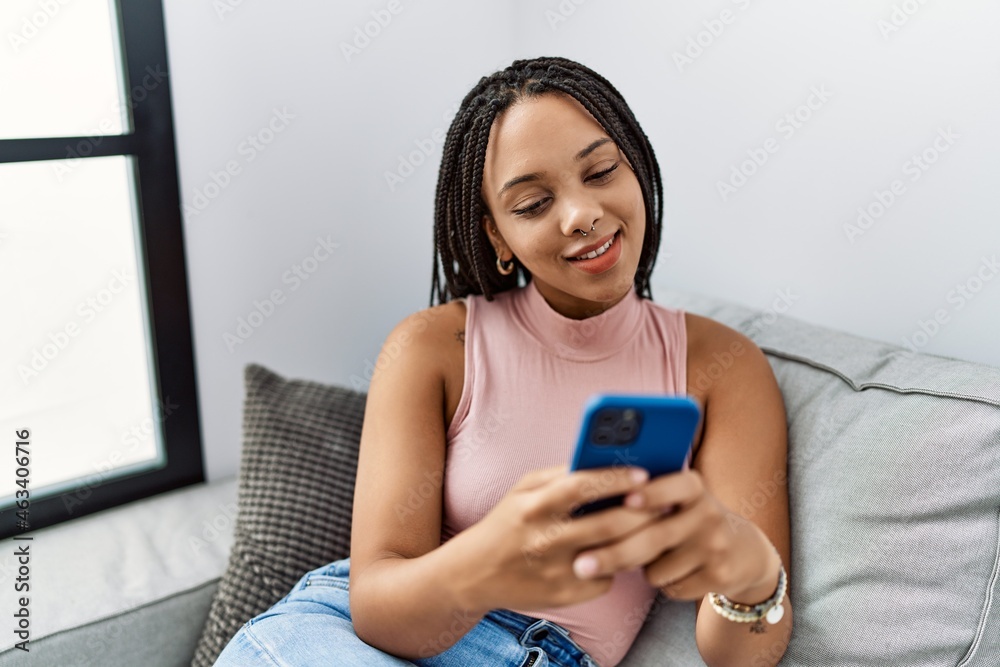 Young african american woman smiling confident using smartphone at home Young african american woman smiling confident using smartphone at home