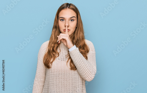 Young blonde woman wearing casual clothes asking to be quiet with finger on lips. silence and secret concept.