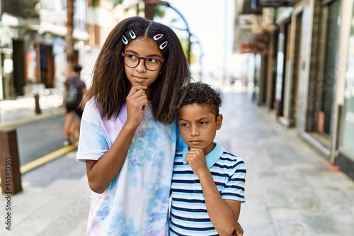African american family of bother and sister standing at the street serious face thinking about question with hand on chin, thoughtful about confusing idea