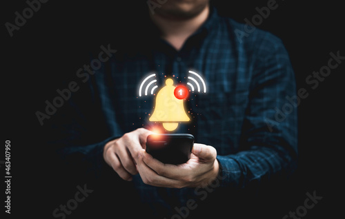 фотографія Businessman holding smartphone with virtual yellow bell ringing for application notification alert concept
