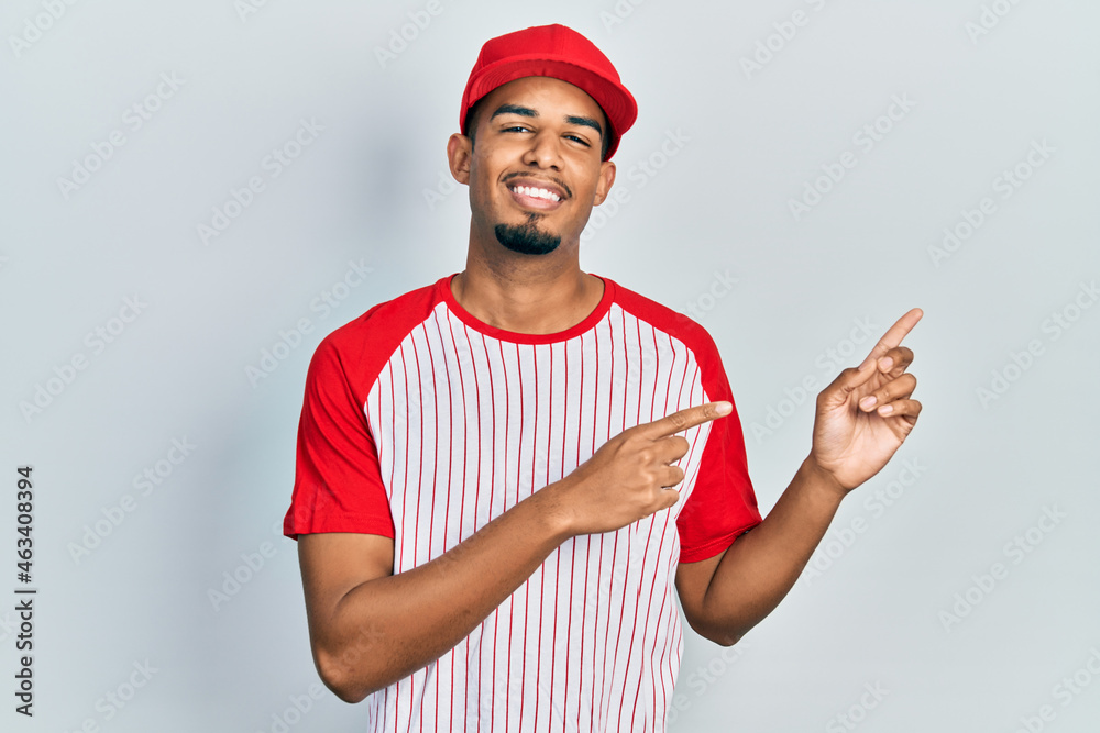 Young african american man wearing baseball uniform celebrating victory with happy smile and winner expression with raised hands