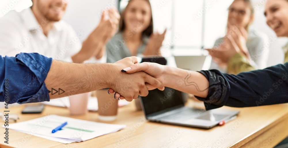 Group of business workers smiling and clapping to partners handshake at the office. Group of business workers smiling and clapping to partners handshake at the office.