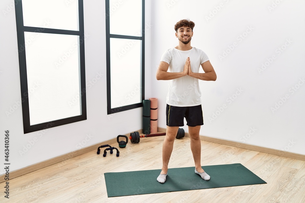 Young arab man smiling confident training yoga at sport center Young arab man smiling confident training yoga at sport center