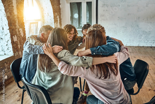Young people sitting and hugging each other in corporate team building meetings or in group therapy sessions.