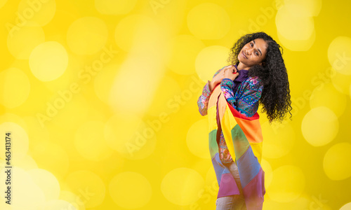 Mujer afroamericana en fondo amarillo con la bandera de la diversidad y luces 