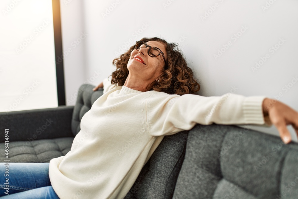 Obraz premium Middle age hispanic woman smiling confident wearing glasses at home