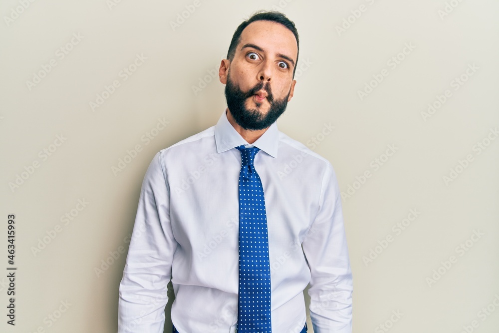 Young man with beard wearing business tie making fish face with lips, crazy and comical gesture. funny expression. Young man with beard wearing business tie making fish face with lips, crazy and comical gesture. funny expression.