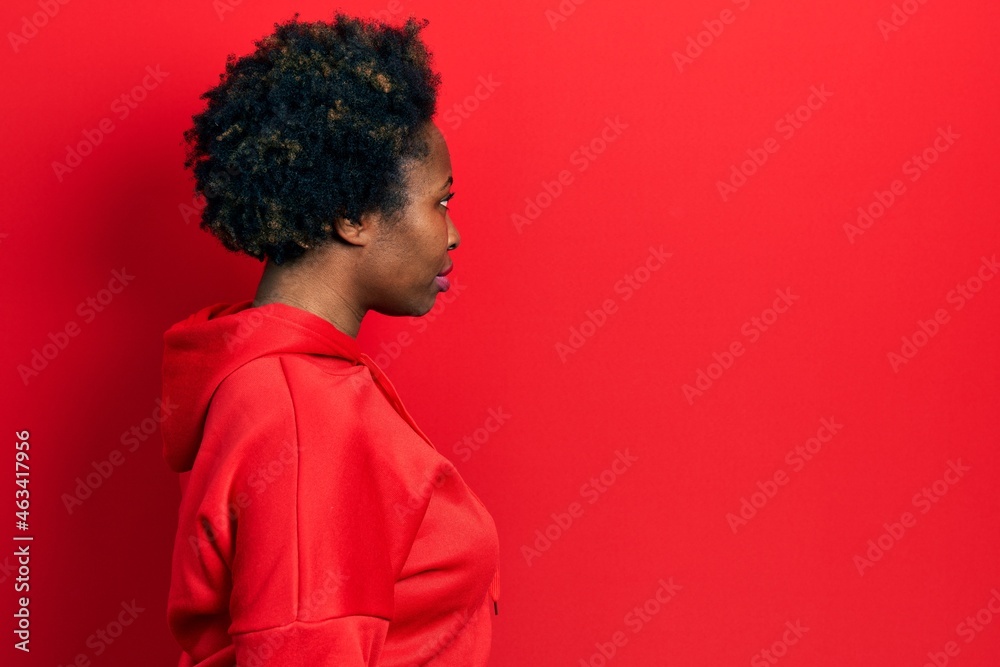 Young african american woman wearing casual sweatshirt looking to side, relax profile pose with natural face with confident smile. Young african american woman wearing casual sweatshirt looking to side, relax profile pose with natural face with confident smile.