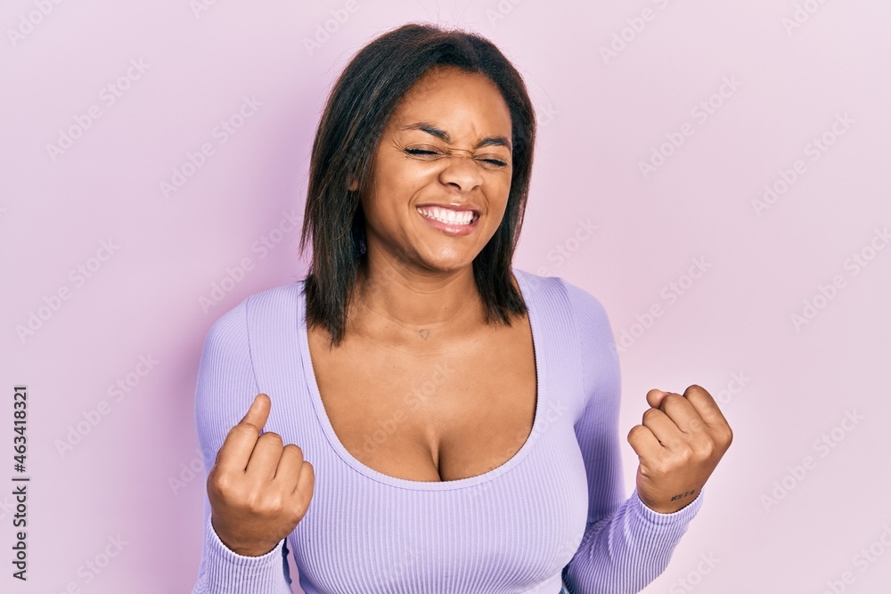 Young african american girl wearing casual clothes excited for success with arms raised and eyes closed celebrating victory smiling. winner concept. Young african american girl wearing casual clothes excited for success with arms raised and eyes closed celebrating victory smiling. winner concept.