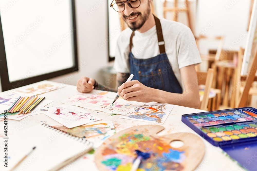 Young hispanic artist man smiling happy drawing at art studio. Young hispanic artist man smiling happy drawing at art studio.