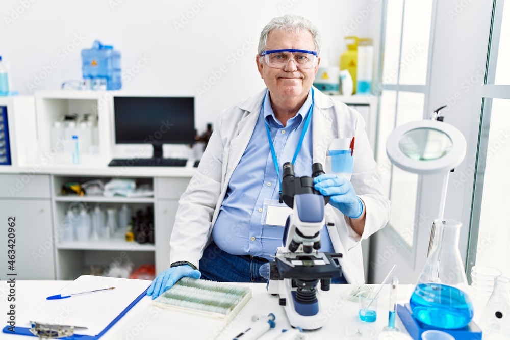 Senior caucasian man working at scientist laboratory with a happy and cool smile on face. lucky person. Senior caucasian man working at scientist laboratory with a happy and cool smile on face. lucky person.