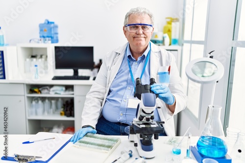 Senior caucasian man working at scientist laboratory with a happy and cool smile on face. lucky person.