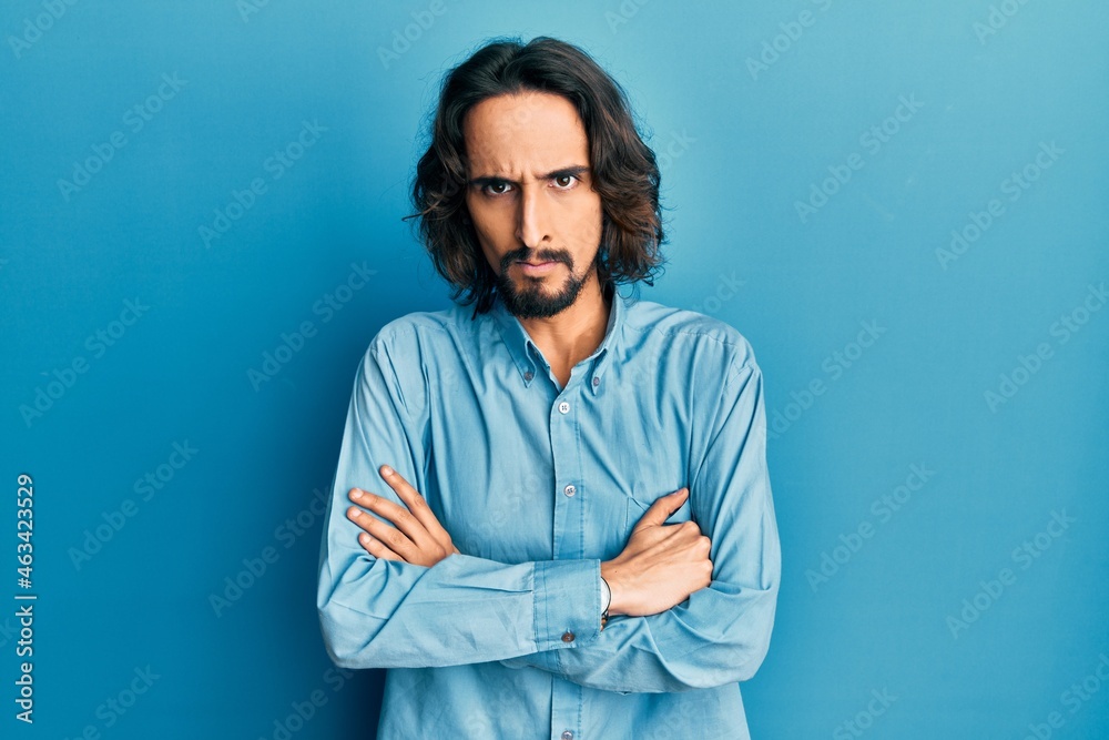 Young hispanic man wearing casual clothes skeptic and nervous, disapproving expression on face with crossed arms. negative person. Young hispanic man wearing casual clothes skeptic and nervous, disapproving expression on face with crossed arms. negative person.