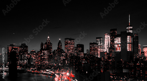 Red lights of Manhattan night skyline shining against a black and white cityscape of downtown New York City