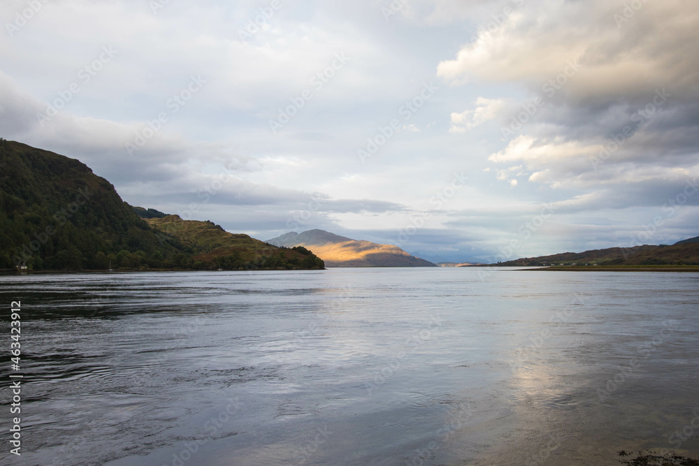 Fototapeta premium The rocky beach at Elgol on the Isle of Skye in Scotland. minimalist Scottish landscape of a misty morning on a calm, Loch Fada lake on the Isle of Skye, Scotland