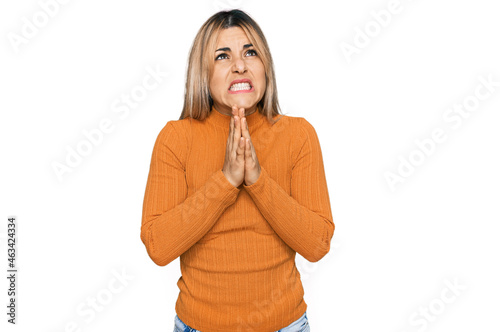 Young caucasian woman wearing casual clothes begging and praying with hands together with hope expression on face very emotional and worried. begging.