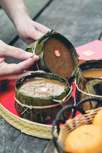 Closeup of hands holding sticky rice cake also known as Nian Gao on wooden table.