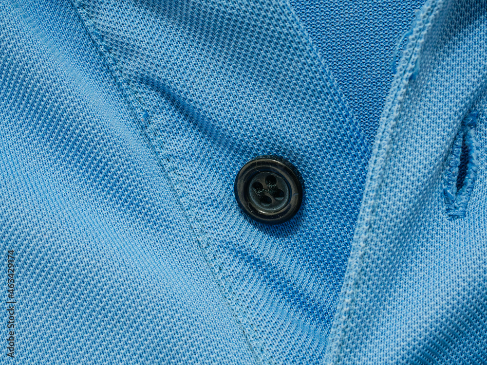 Blue polo shirt with button. Textured background. Textile concept Blue polo shirt with button. Textured background. Textile concept