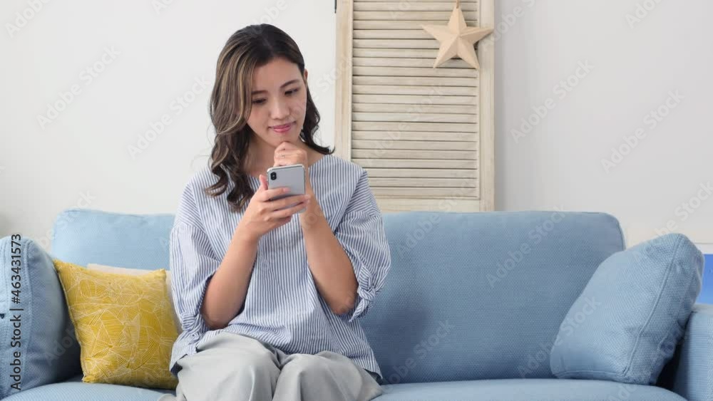 部屋でスマホを持って考える女性 部屋でスマホを持って考える女性