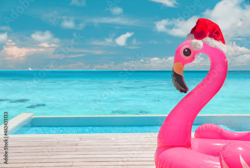 Bild auf Leinwand Christmas beach summer vacation flamingo pool float with santa hat travel background for winter holidays
