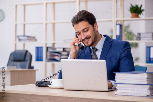 Young handsome employee working in the office