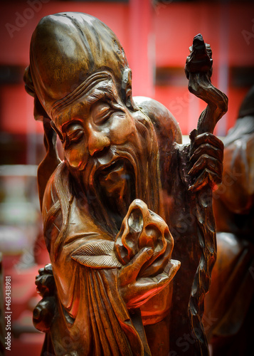 A fragment of a Chinese sculpture of the deity Shou-sin with a peach and a staff. Carved wood, 19th century © Sergey