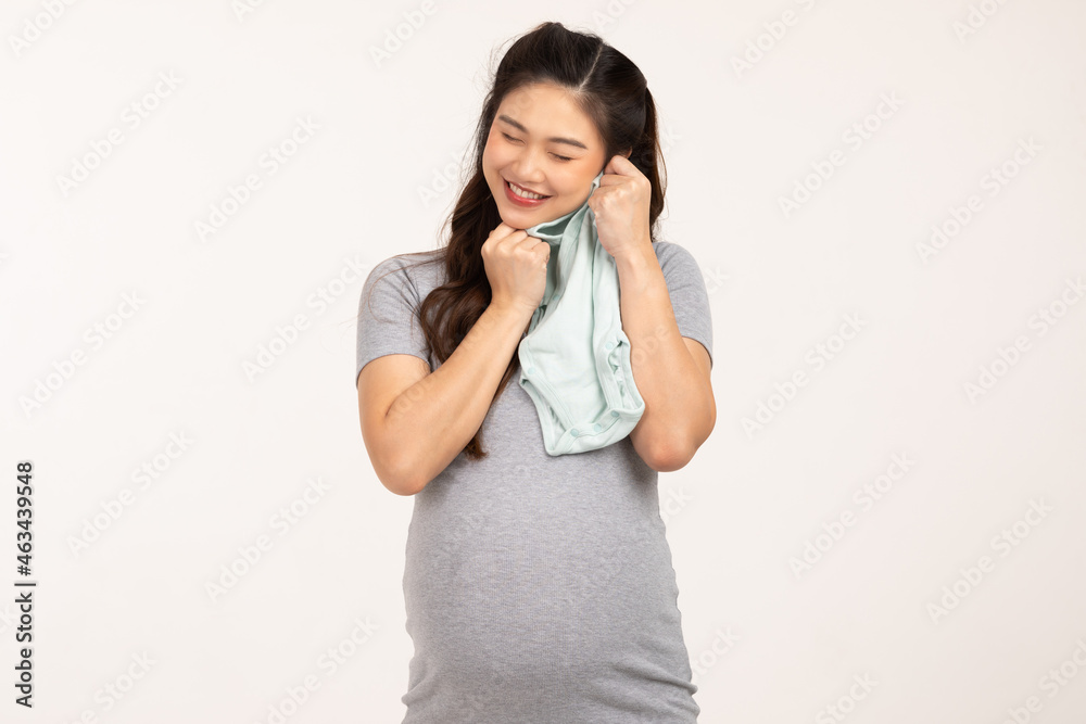Asian pregnant woman holding baby cloth for baby newborn isolated on white background.Pregnant woman packing baby stuff ready for the maternity hospital.Pregnancy Prepare for Newborn Concept Asian pregnant woman holding baby cloth for baby newborn isolated on white background.Pregnant woman packing baby stuff ready for the maternity hospital.Pregnancy Prepare for Newborn Concept