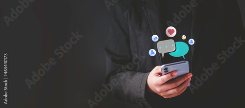 Live Chat on Communication social network Concept. Person hand using smartphone typing, playing social media chatting conversation in chat box icons pop up.