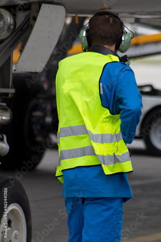 A man in a reflective vest. Technician sits in a turbine and checks the plane's engine before flying. Aviation maintenance, repair. Airport worker. Security check. Malfunctions of the aircraft engine. photo