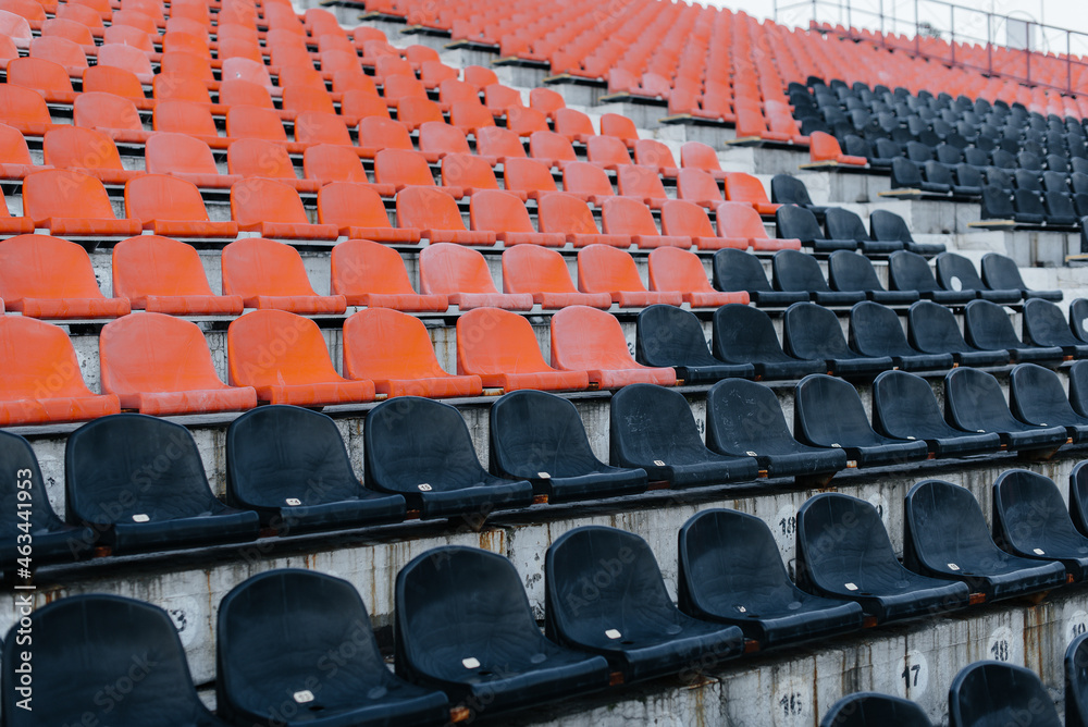Fototapeta premium Empty stands and seats for fans and fans in the open-air stadium. Lack of fans during the pandemic.