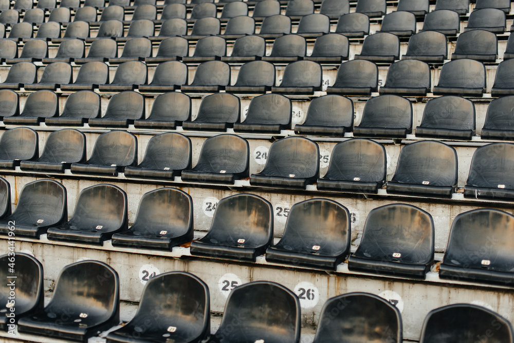 Fototapeta premium Empty stands and seats for fans and fans in the open-air stadium. Lack of fans during the pandemic.