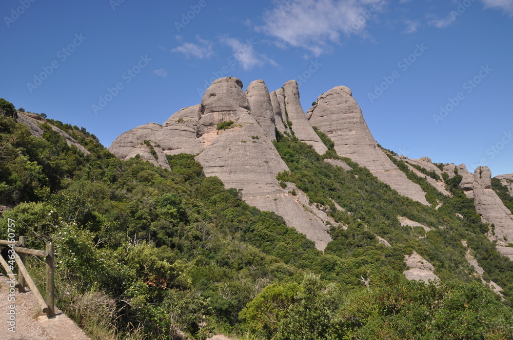 Panoramic view of the mountain. Peaked mountains without vegetation. Blue sky with clouds.