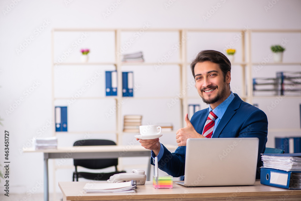 Young male employee drinking coffee during break