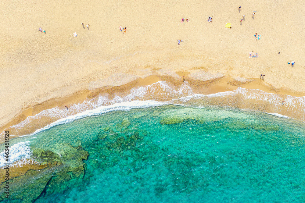 Top view aerial drone photo of beautiful beach with beautiful turquoise water, sea waves and people. Vacation travel background. Greece