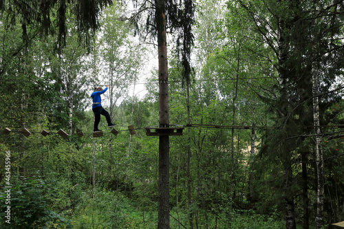 Boy overcomes obstacle course in forest © Arkady Chubykin
